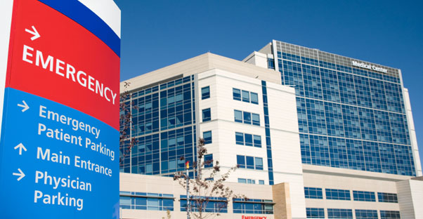 A sign denotes which direction to go to reach the emergency room of a hospital.