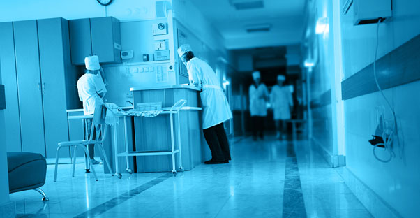 a colon cancer doctor checks in at a nurse station in the hospital