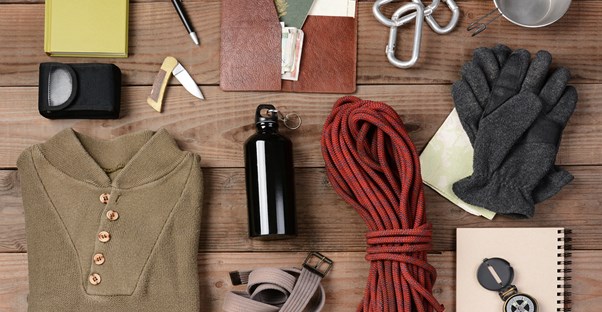 An array of clothing pieces and maps are essential for backpacking.