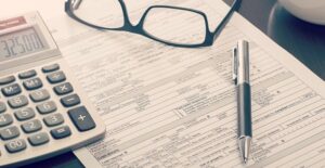 Person taking off their glasses to fill out an application for an installment loan