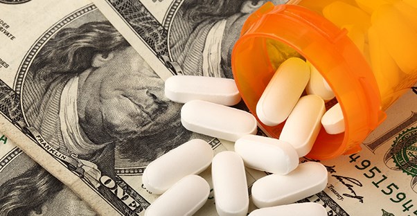 medications in a bottle spilling over a stack of cash
