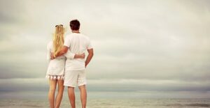 Couple who didn't register for their wedding standing on a beach