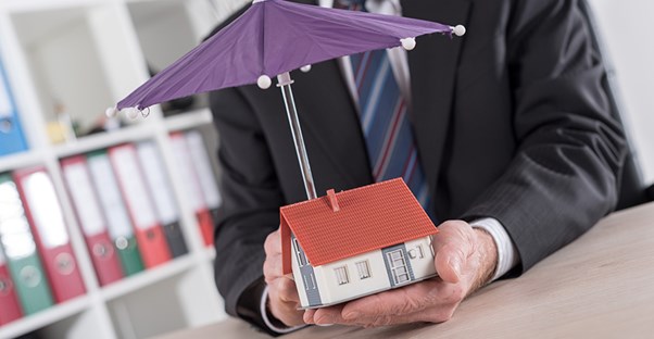 Umbrella covering a house representing umbrella insurance