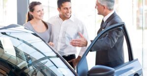 Couple with a family shopping for a new family car