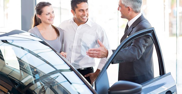 Couple with a family shopping for a new family car