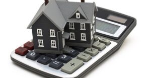 tiny house on top of a calculator