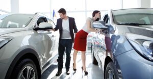 man and woman inspecting different cars