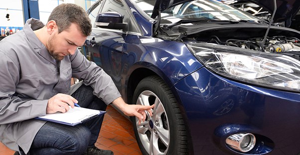 guy studying a new car and looking at paper