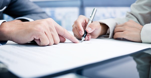 lawyer showing where to sign when filing for mesothelioma lawsuit