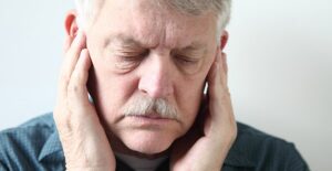 An elderly man struggles with TMJ