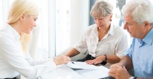 elderly couple going over different policies with life insurance agent