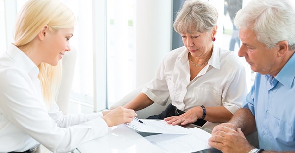 elderly couple going over different policies with life insurance agent