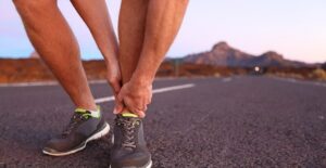 a man holds his foot in pain