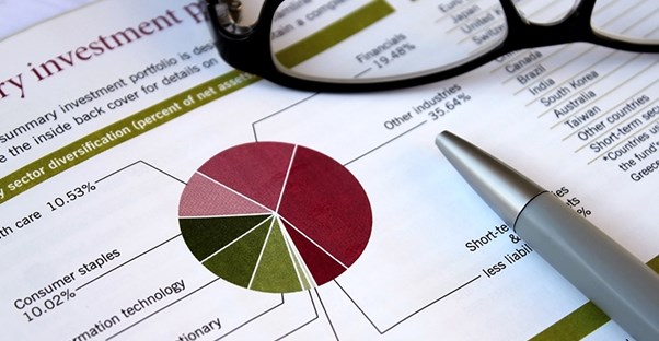 pen and glasses on top of dividend papers