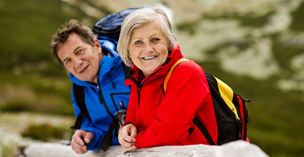 Two older hikers enjoy the trails of a national park.