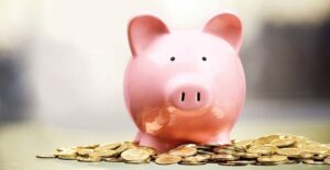 piggy bank sitting on top of coins