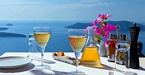 A stylish dining table is set up overlooking the ocean.