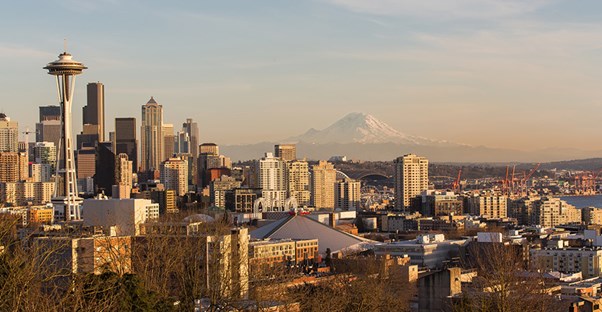 Downtown Seattle and the Space Needle are situated in front of Mount Rainier in the distance.