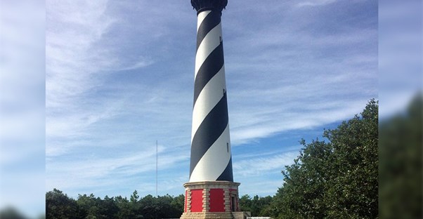 The black and white Cape Hatteras lighthouse on the shore in Buxton, North Carolina.
