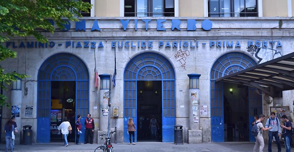 People gather in front of a blue building in a public square in the Mexico City neighborhood of Roma.