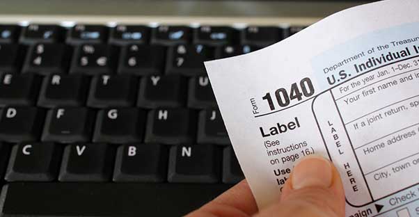 Person carefully filing their taxes to avoid making mistakes