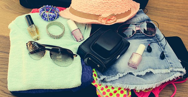 Towels, clothes, and accessories are folded neatly and ready for packing.