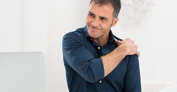 Man with shoulder pain at desk