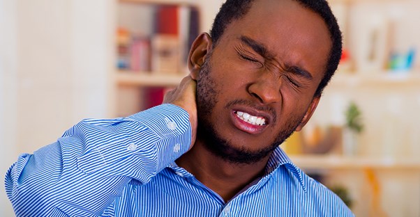 man in blue shirt having neck pain