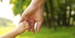 child holding parents hand deciding on child custody lawyer