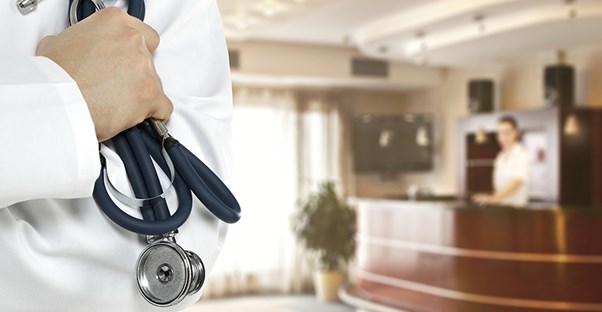 doctor holding stethoscope checking on coma patient
