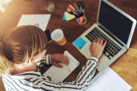 Overhead shot of a young business woman with a degree in entrepreneurship working on her laptop