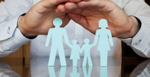 mans hands providing umbrella over a family to represent term life insurance