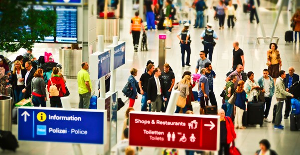 A line of people wait to go through airport security.