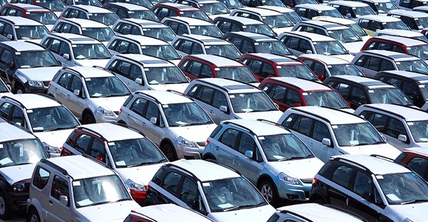 A view from slightly above of a lot of vehicles lined up and ready for an auto auction