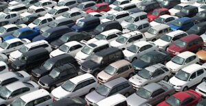 above view of cars in lines and rows prepared for a dealer car auction which is different from a public vehicle auction