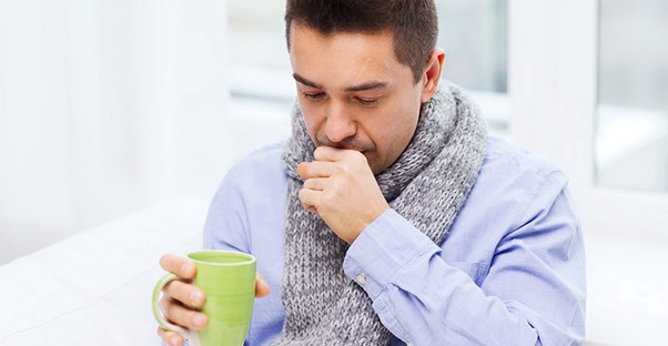 guy coughing and drinking tea