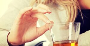 woman resisting a drink of alcohol because she is having delirium tremens symptoms