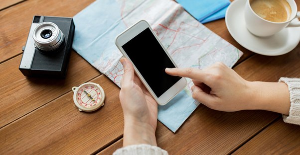 A traveler checks her phone for last minute deals.