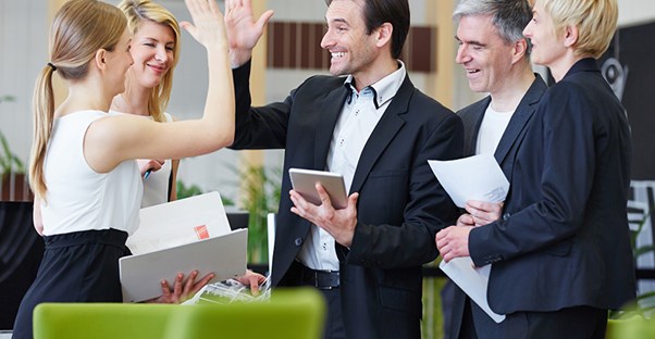 coworkers high fiving because they won an employee incentive