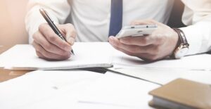 a man writing down contact info from his phone for a job he got with a business administration degree