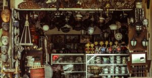 A shop stall at an open-air market displays multiple wares and knickknack.