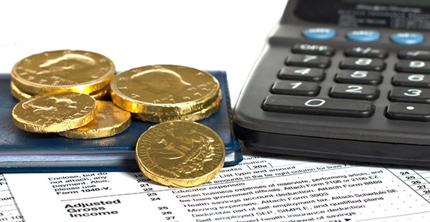 coins, check book, and calculator sitting on top of an adjusted gross income calculation form