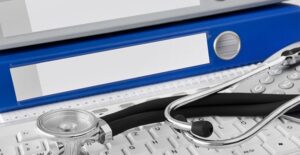 stethoscope on keyboard with binders full of leprosy information