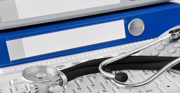 stethoscope on keyboard with binders full of leprosy information