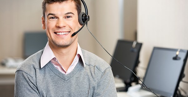 young man smiling while working in an outsourced call center