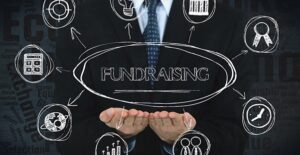 a man sketching fundraising ideas and steps on a chalk board to figure out how to fundraise