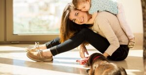 A babysitter plays with a child and a dog