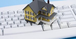 A tiny toy house sits upon a keyboard