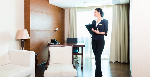 A hospitality manager takes notes about a room