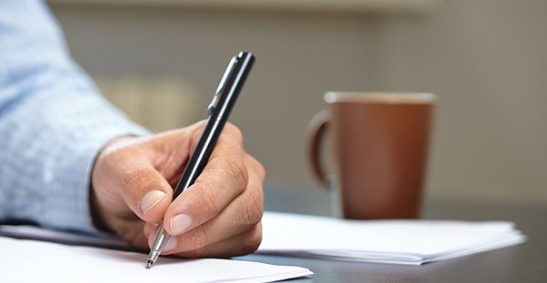 person writing as they are choosing a beneficiary